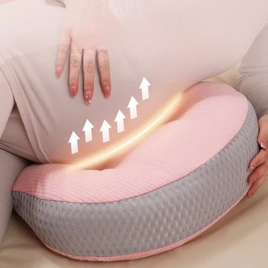  A pregnant woman comfortably resting with a C-shaped pregnancy pillow, designed to provide full-body support for the belly, lower back, and hips. Made from breathable, hypoallergenic fabric, this ergonomic pillow promotes healthy posture, reduces pressure on the spine, and enhances sleep quality. Perfect for sleeping, lounging, or postpartum nursing.