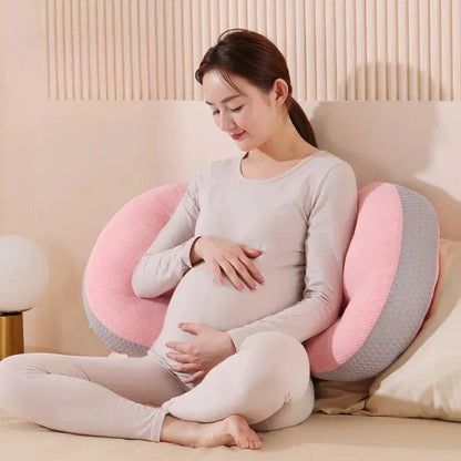  A pregnant woman comfortably resting with a C-shaped pregnancy pillow, designed to provide full-body support for the belly, lower back, and hips. Made from breathable, hypoallergenic fabric, this ergonomic pillow promotes healthy posture, reduces pressure on the spine, and enhances sleep quality. Perfect for sleeping, lounging, or postpartum nursing.